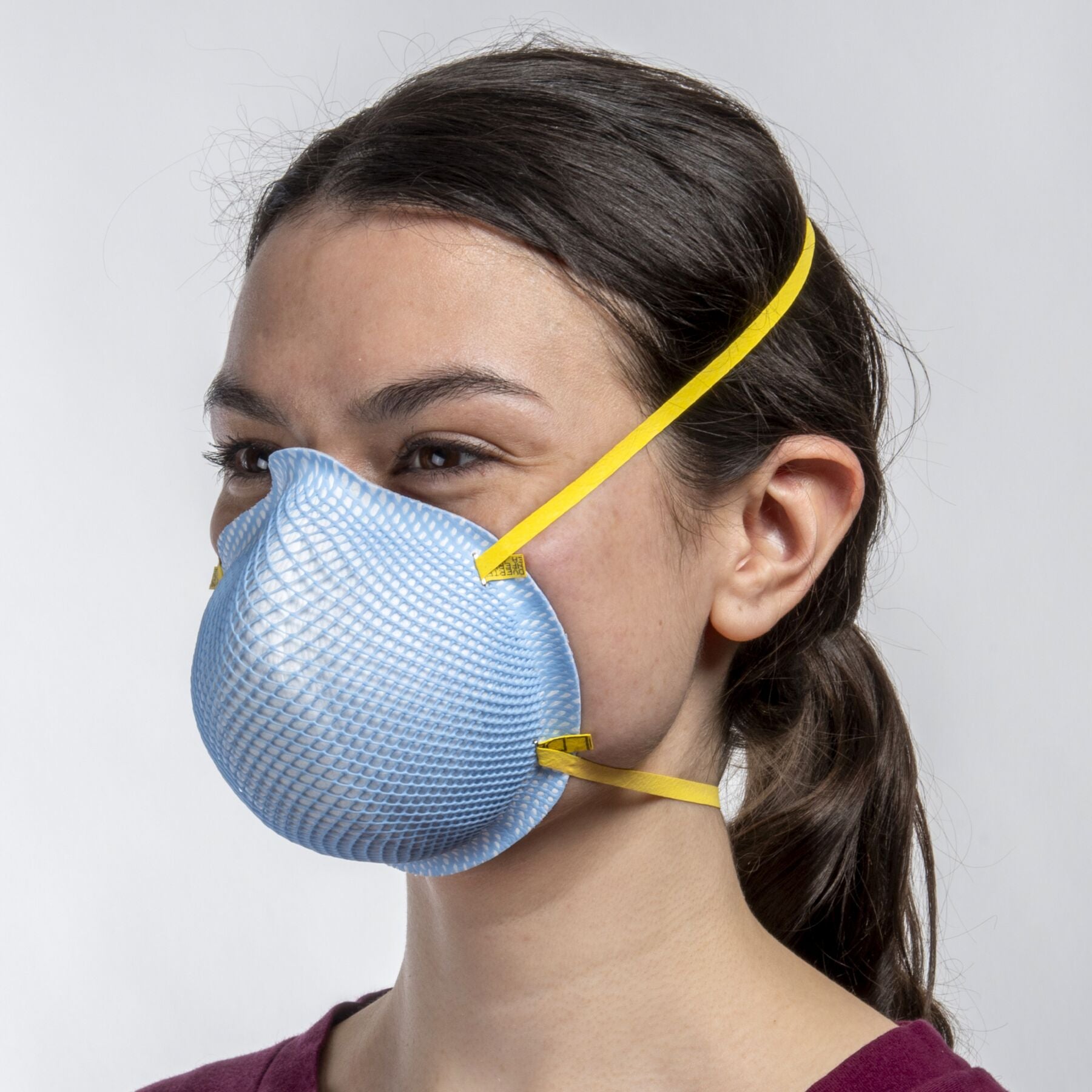 Young petite woman girl nurse wearing blue extra small (XS) healthcare NIOSH N95 surgical respirator from Canada Strong Masks.