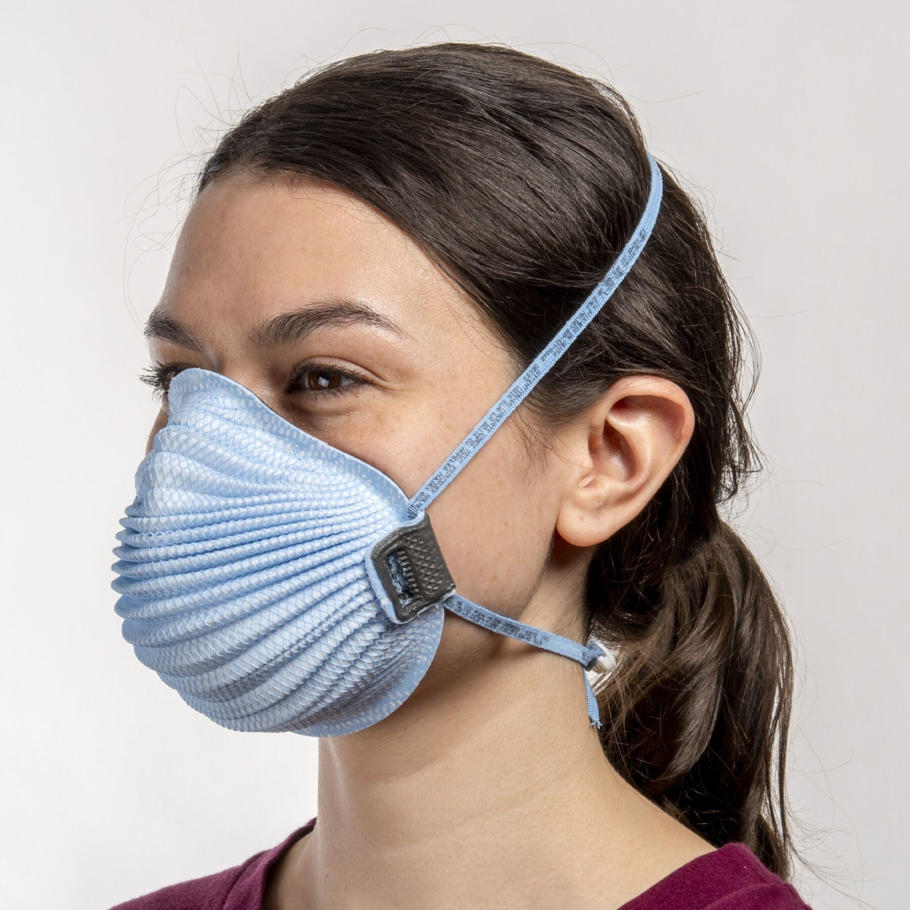 Woman healthcare worker wearing small blue Airwave 4151 NIOSH N95 surgical respirator from Canada Strong Masks.